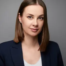 Kobieta w granatowej marynarce, z delikatnym uśmiechem. Idealny przykład, jak dobrze wyjść na zdjęciu do dowodu.