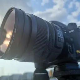 Obiektyw z filtrem ND 32000, gotowy do uchwycenia zachodu słońca nad portem.